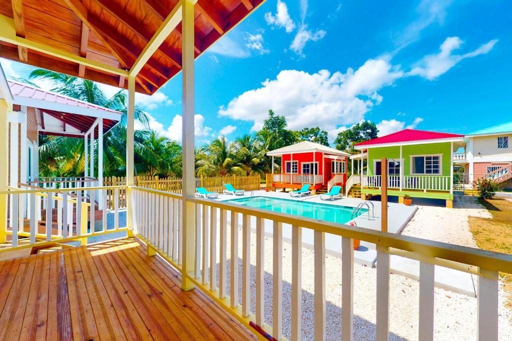 a house with a deck and a swimming pool at FLA at Hummingbird Estate Gold Standard Certified in Dangriga