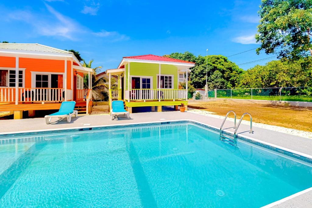 a swimming pool in front of a house at Bella at Hummingbird Estate Gold Standard Certified in Dangriga