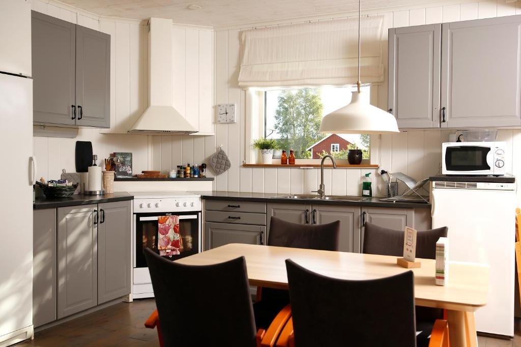 a kitchen with a wooden table and a kitchen with white cabinets at Övre Jäder 1 - Jönåker in Jönåker