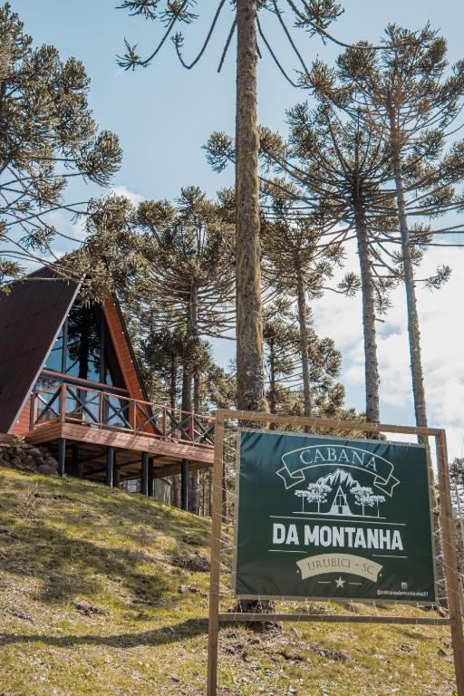 a sign in front of a building with a tree at URUBICI - Cabana da Montanha in Mundo Novo