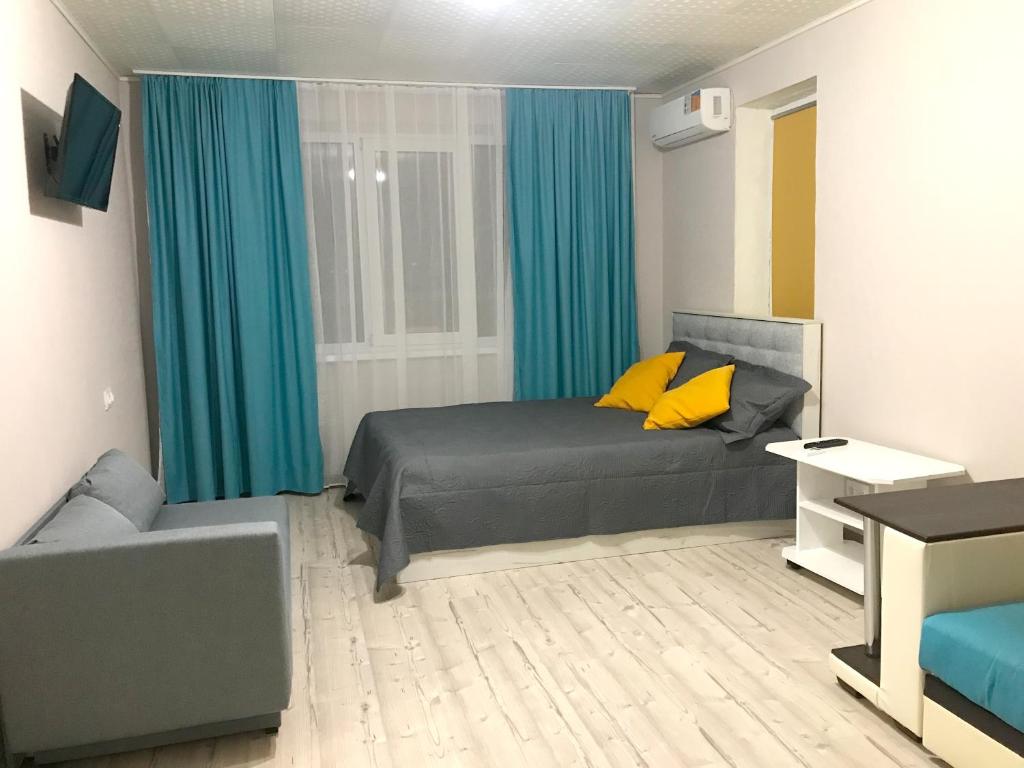PashkovskiyにあるApartments on Sormovskayaのベッドルーム(ベッド1台、青いカーテン付)