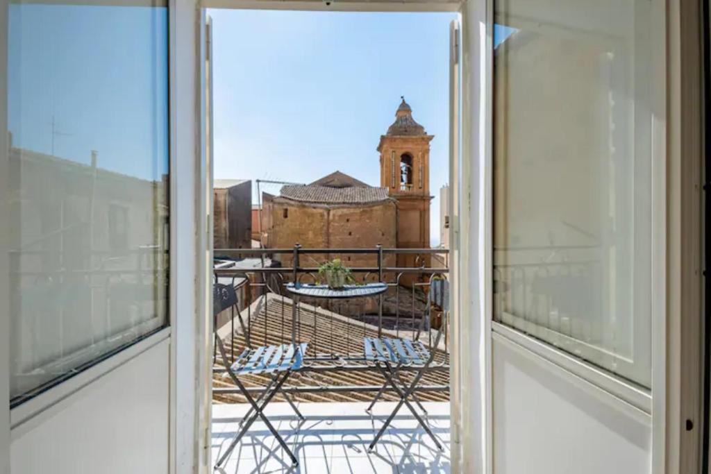 ein offenes Fenster mit Blick auf ein Gebäude in der Unterkunft B&B Home Visit in Agrigento