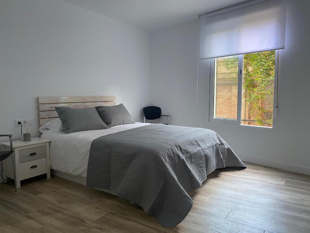 um quarto branco com uma cama e uma janela em Cozy flat in La Petxina B em Valência