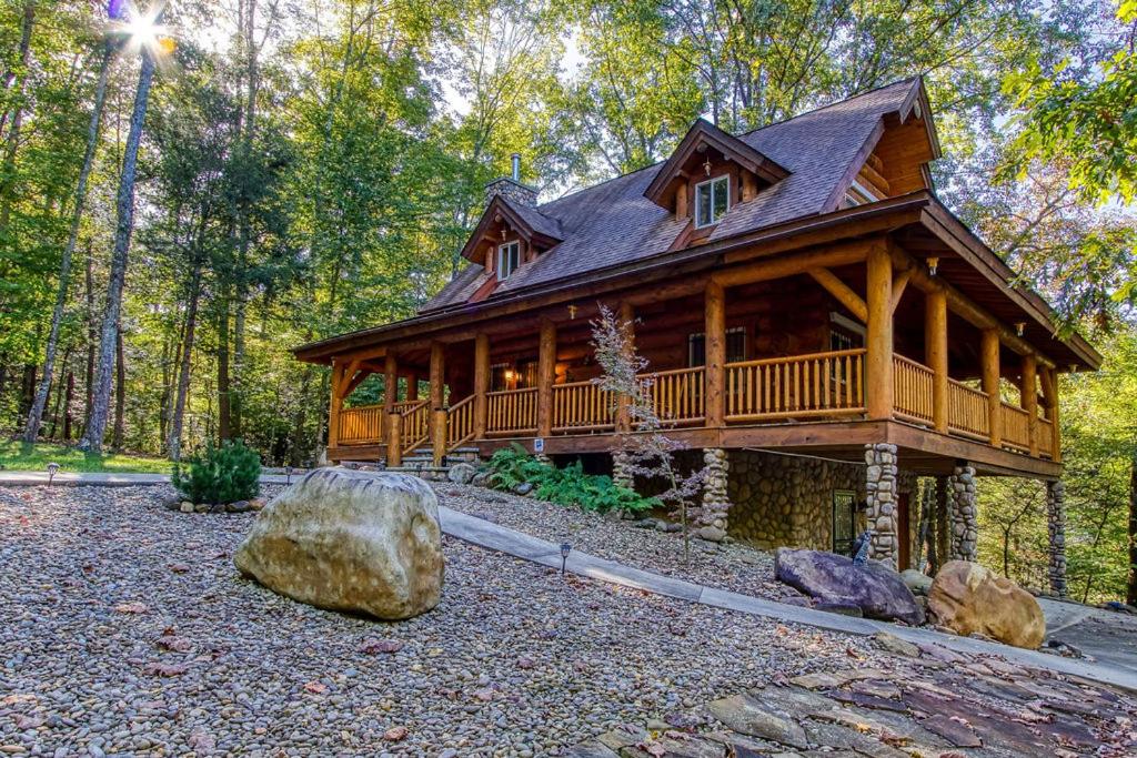 a log cabin in the woods with a large rock at Sonshine By The Stream, Next To A Stream, 560 FREE tickets each paid day in Cosby