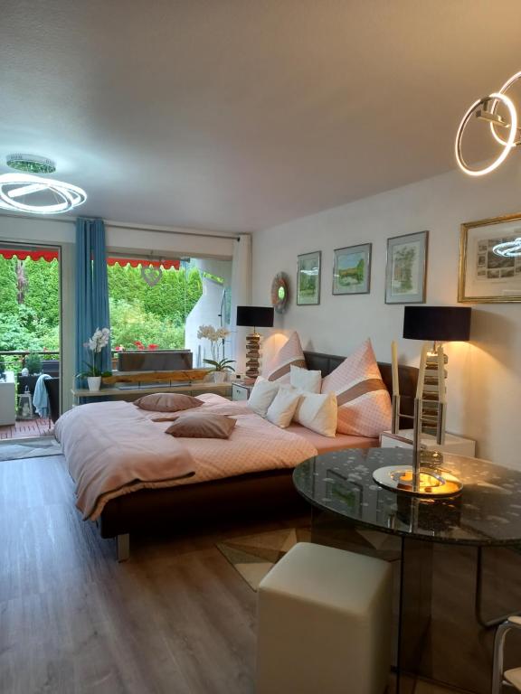 Appartement Herrlich في باد فيلدباد: غرفة نوم بسرير كبير وطاولة زجاجية