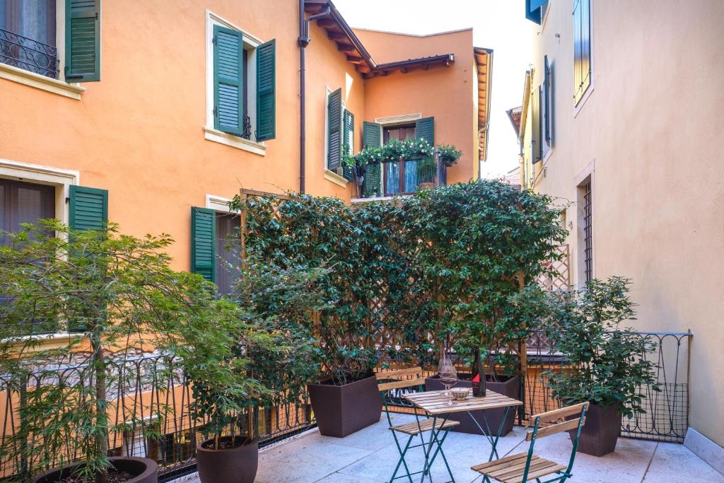 ヴェローナにあるLa terrazza in centroの建物の前にテーブルと椅子のある中庭