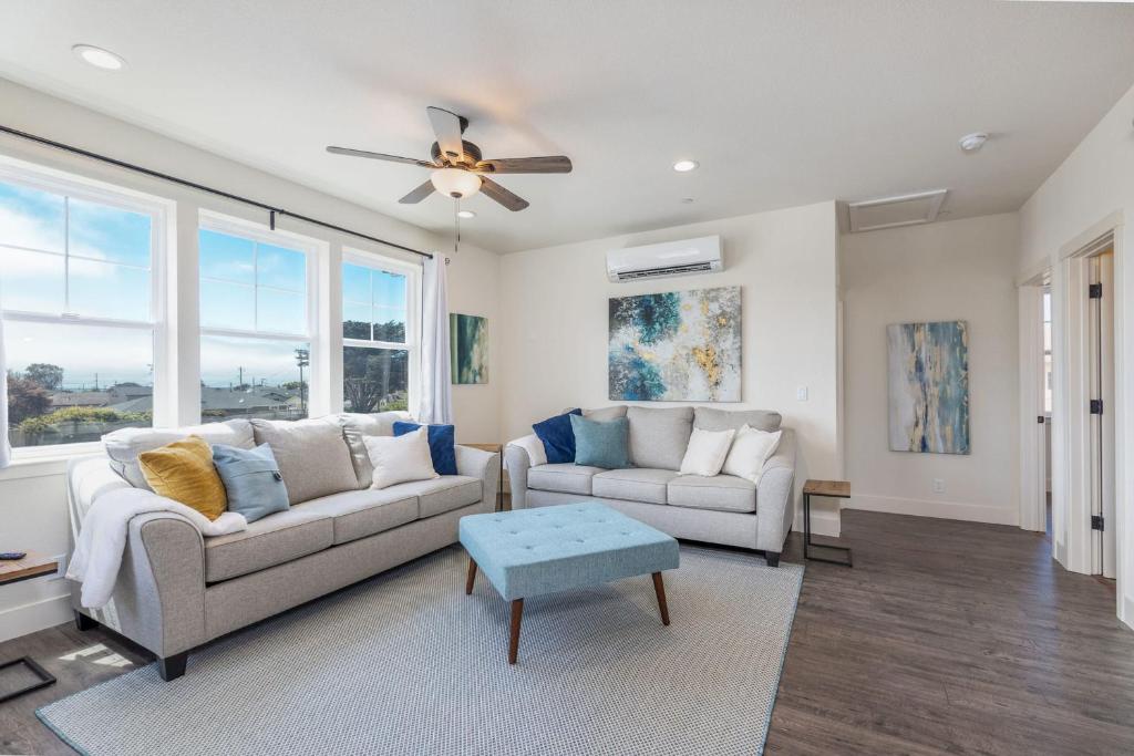 a living room with two couches and a ceiling fan at Beach Town Home - Walk to Beaches Downtown Activities and so much more in Half Moon Bay