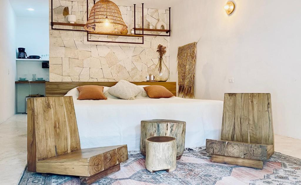 een slaapkamer met een bed en wat houtblokken bij Casa Macay in Tulum