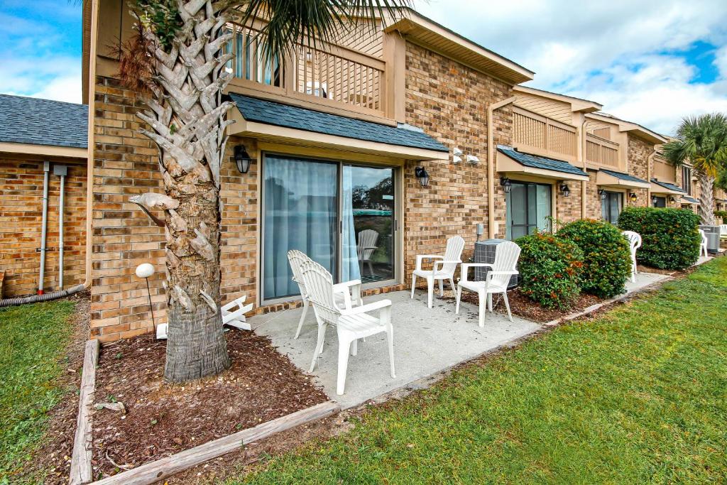 een patio met stoelen en een boom voor een huis bij Eagle Haven - H1 in Myrtle Beach