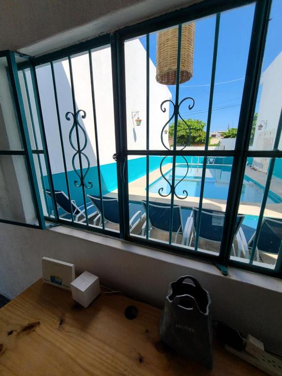 Habitación con vistas a la piscina a través de las ventanas. en Madre Cuixe Suites en Peñita de Jaltemba