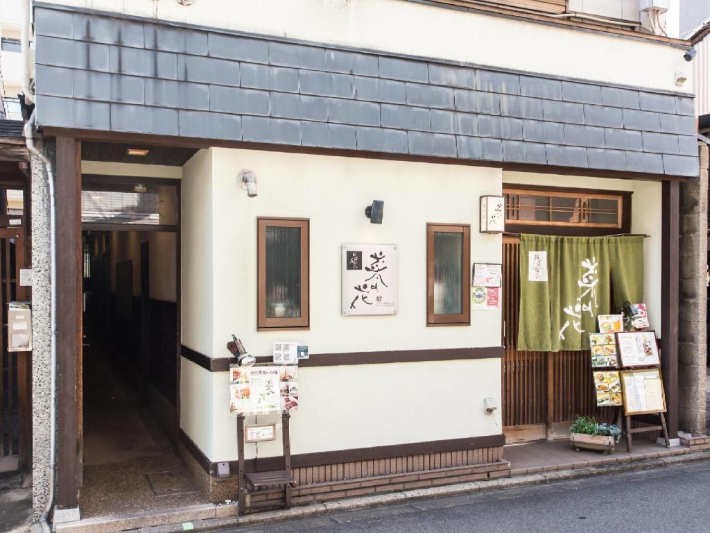 a small white building with a black roof at Woman Only Guesthouse Nanohana (Female only) in Kyoto