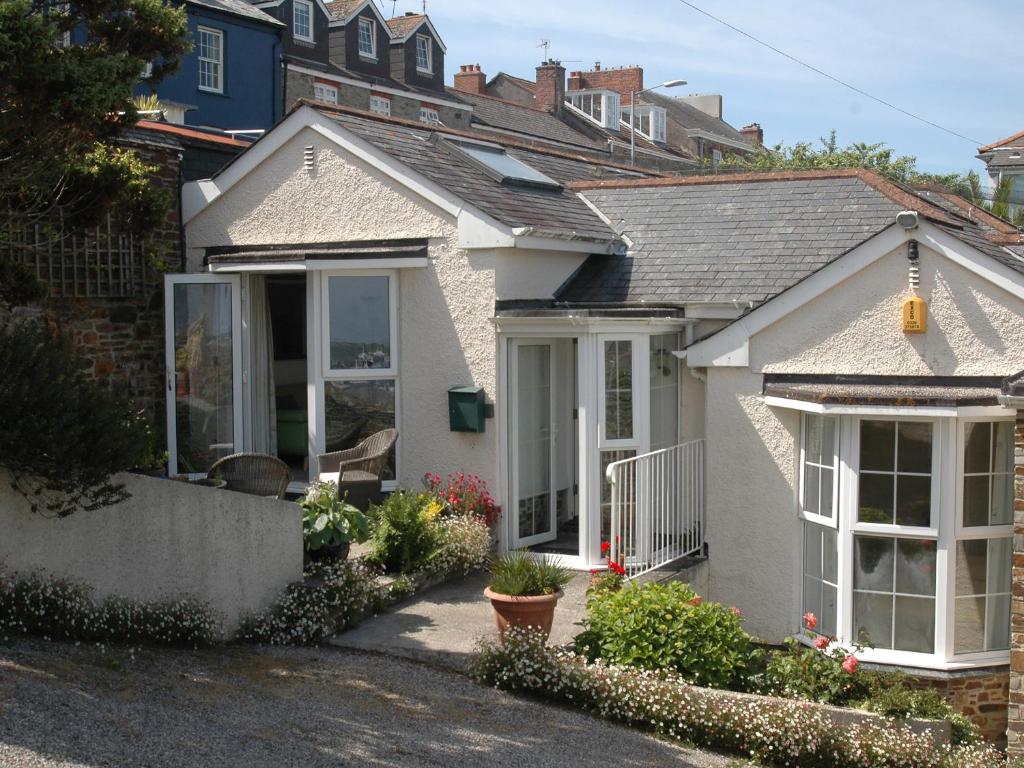 uma casa branca com janelas e plantas à sua frente em Seabien em Falmouth