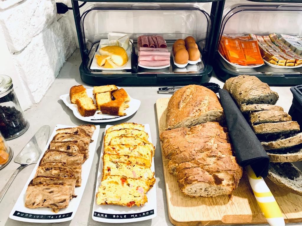 a table topped with different types of bread and pastries at Hôtel Gaspard in Le Touquet-Paris-Plage