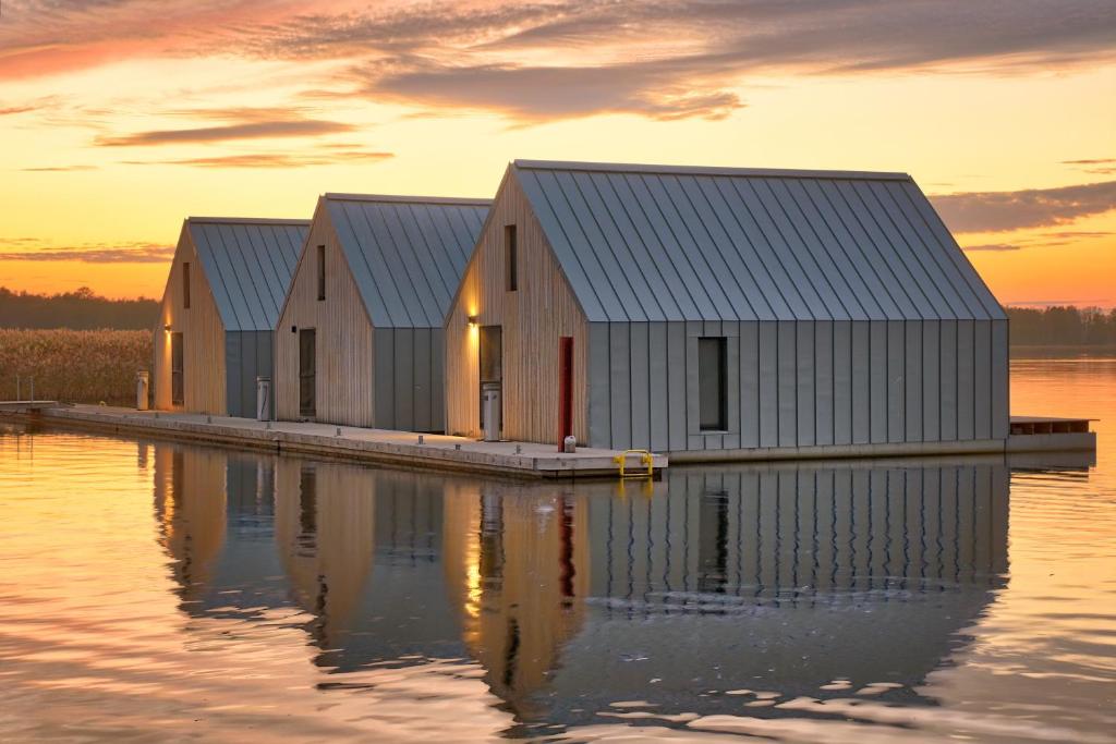 una fila de casas en un muelle sobre un cuerpo de agua en Domy na Wodzie na Mazurach, en Pisz