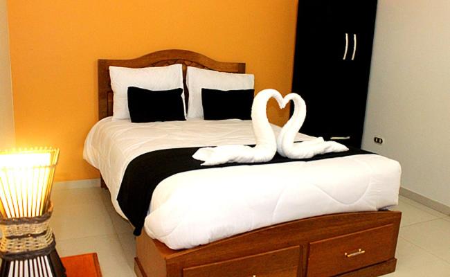 una camera da letto con un letto con due cigni sopra di Hostal Universal Huaraz a Huaraz