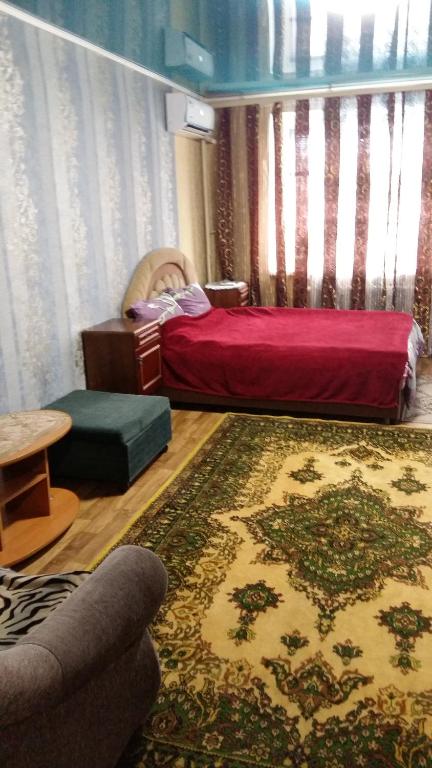 sala de estar con cama y alfombra en кв посуточно на заречном, en Alfërovo