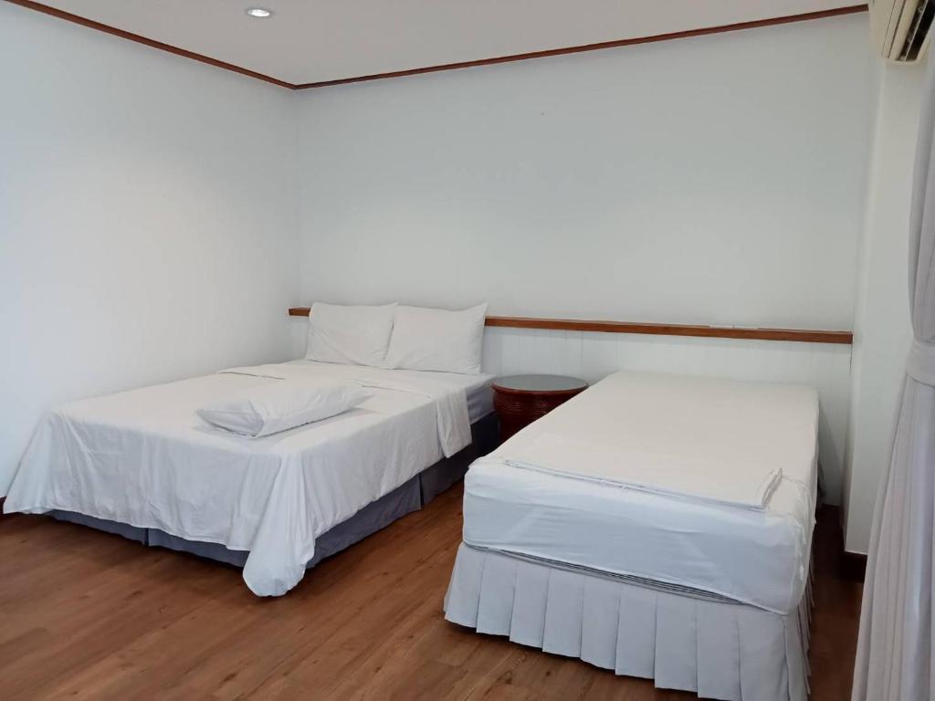 Postel nebo postele na pokoji v ubytování BaanBusarin Hotel
