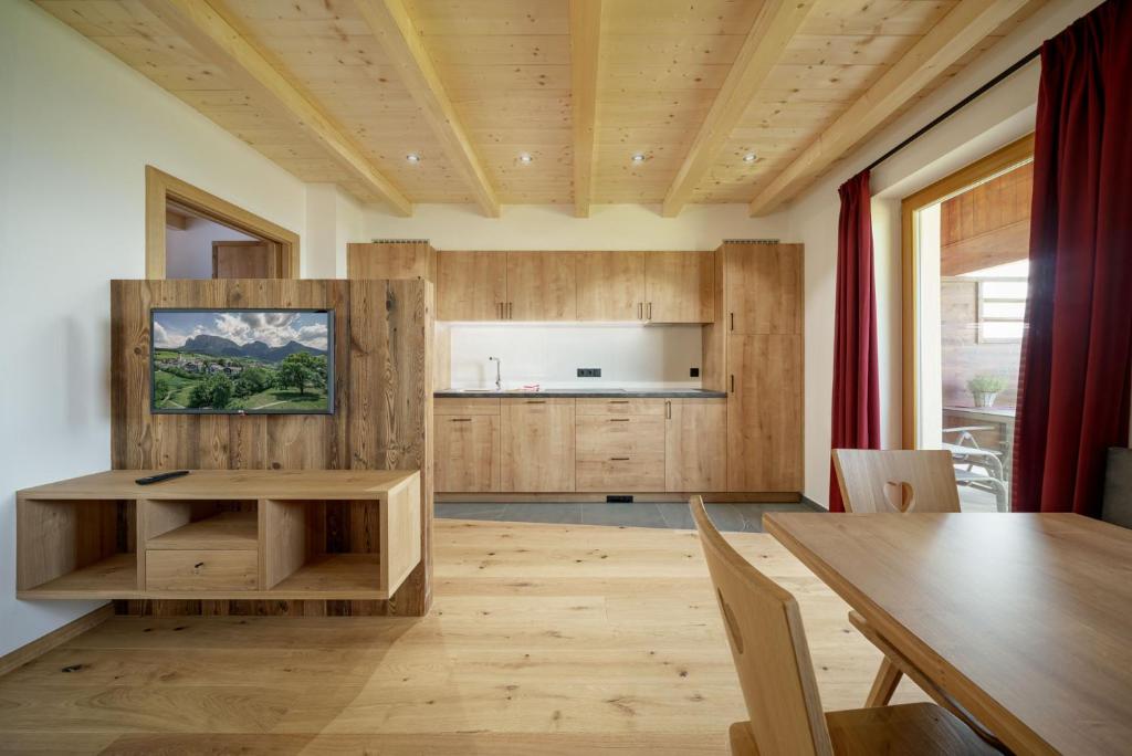 Il comprend une cuisine et une salle à manger avec une table en bois. dans l'établissement Schartnerhof Ferienwohnung Salbei, à Vols am Schlern