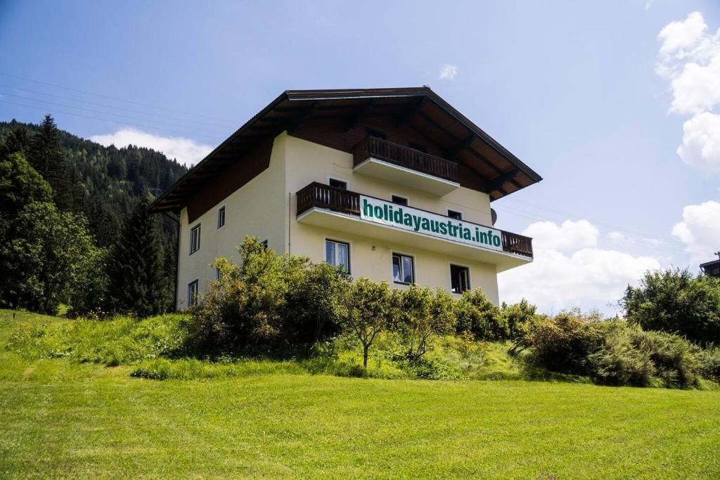 a building on a hill with a grass field at 10-Bedroom House near Obertauern for 30 people in Radstadt
