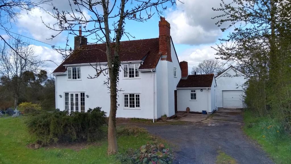 a white house with a driveway in front of it at Worfield in Hereford