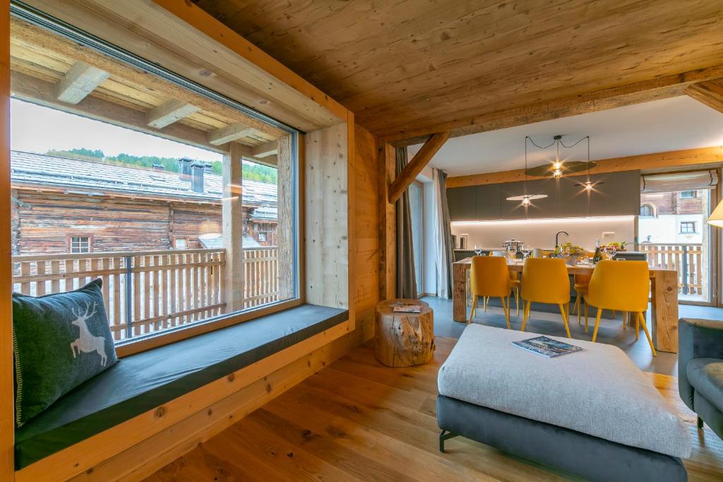 een kamer met een groot raam en een eetkamer bij Besseghini Apartments in Livigno