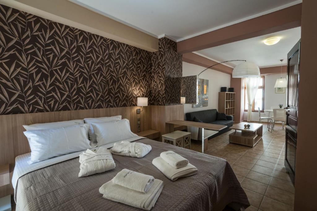 a bedroom with a large bed with towels on it at Horizon Deluxe House in Chania