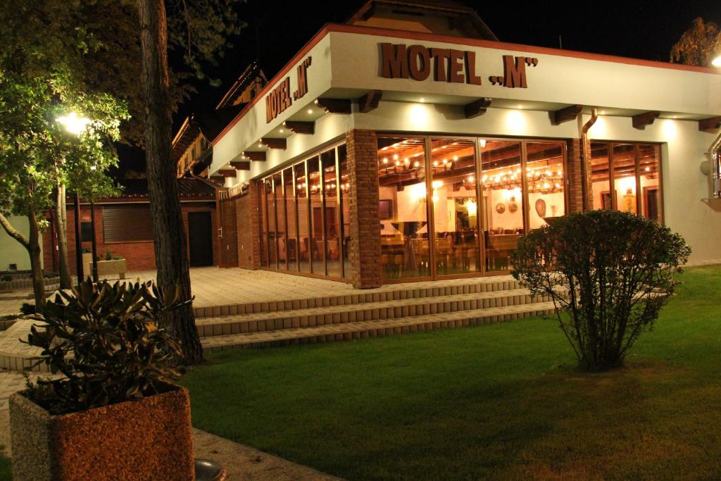 a building with a hotel lit up at night at Motel M in Malacky