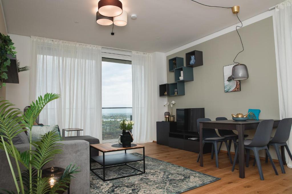 a living room with a couch and a table and a dining room at Great apartment with view and heated rooftop Pool in Vienna