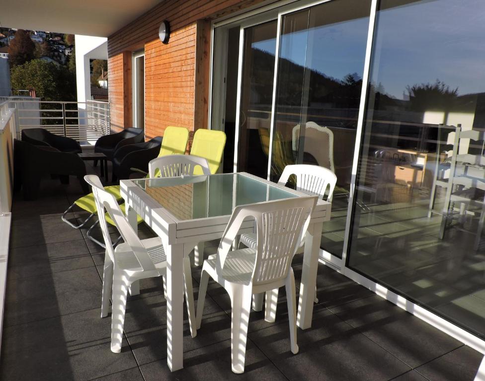 a white table and chairs on a balcony at appartement avec balcon terrasse plein sud proche lac et centre ville wifi in Gérardmer