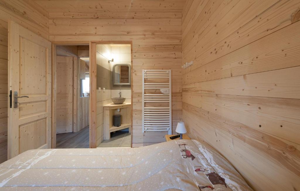 a bedroom with a bed in a wooden wall at Odalys Chalet D&#39;Alice in Les Menuires