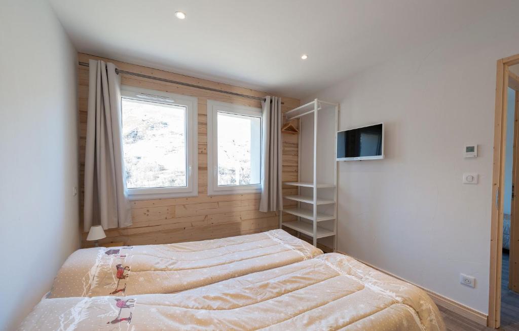 a bedroom with two beds and a tv in it at Odalys Chalet D&#39;Alice in Les Menuires