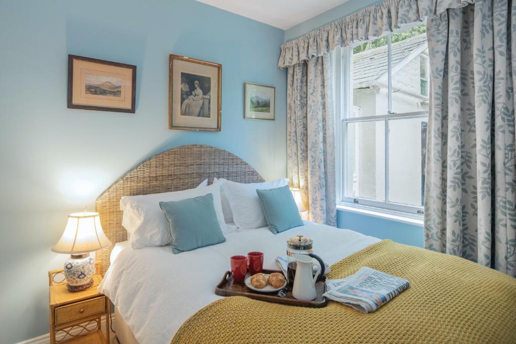 a bedroom with a bed with a tray of food on it at The Nook at Henge Estate in Salisbury