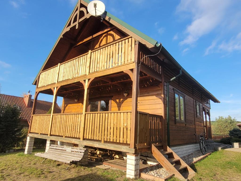 a large wooden cabin with a gambrel roof at Kaszubskie Zacisze 2 dom nad jeziorem, sauna, balia ogrodowa in Lipusz