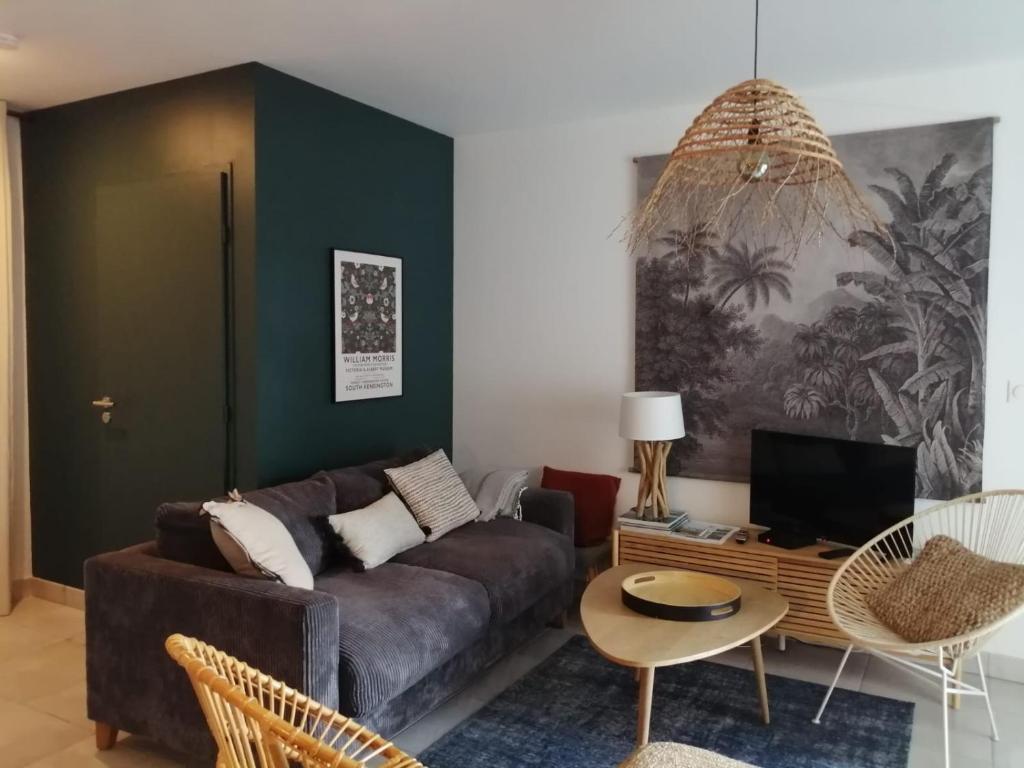 - un salon avec un canapé et une table dans l'établissement La plage de Val Andre au pied de l appartement, à Pléneuf-Val-André