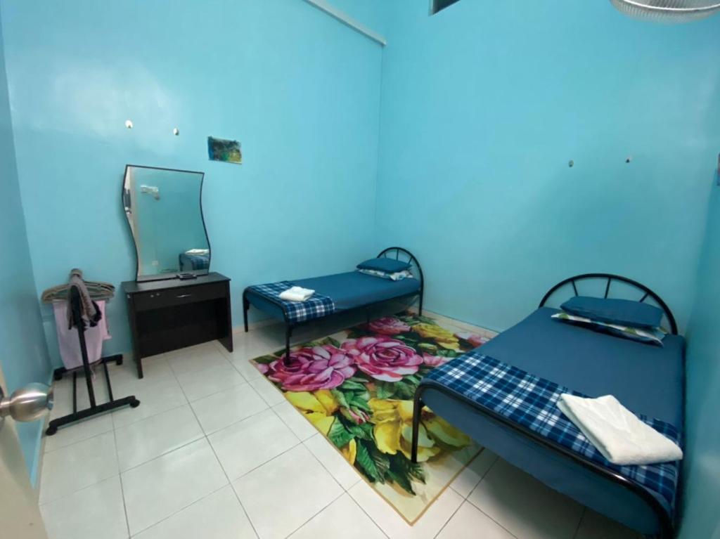 a room with two beds and a mirror at illiy's homestay in Tangga Batu