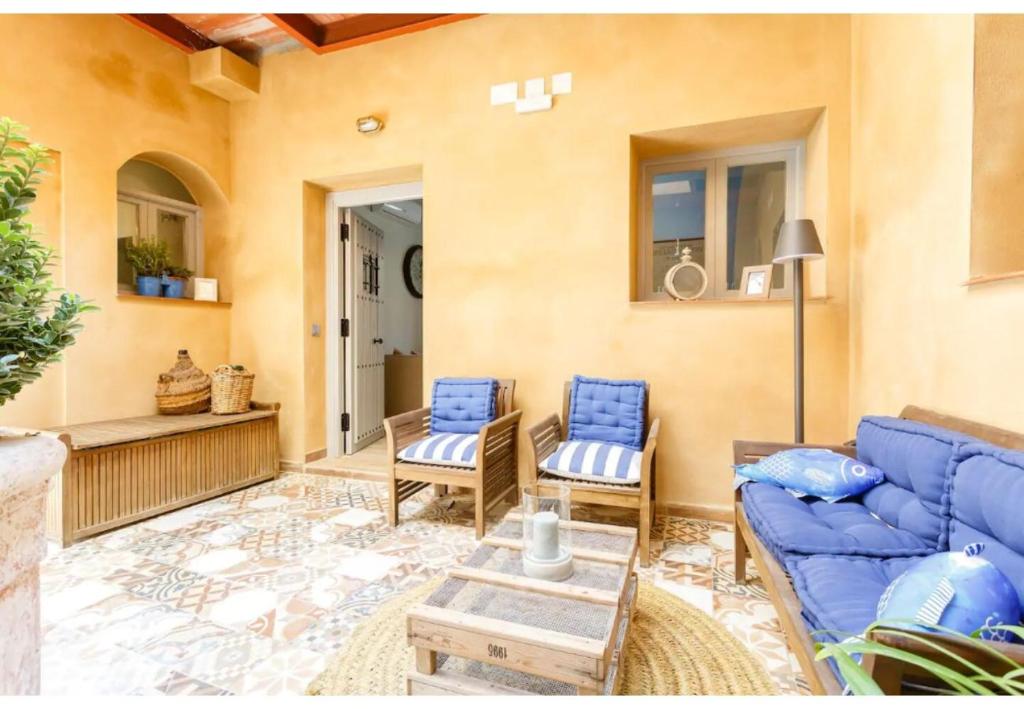 sala de estar con sofá azul y sillas en PATIO-Caleta Beach Home by Cadiz4Rentals, en Cádiz