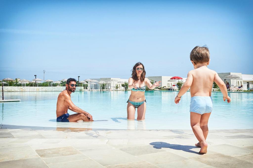 um grupo de pessoas na água em uma piscina em Relais Masseria Le Cesine - CDSHotels em Vernole