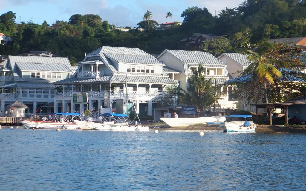 un grupo de casas y barcos en el agua en Superb Split Level Waterside Apt, Marigot Bay, St Lucia WI, en Castries