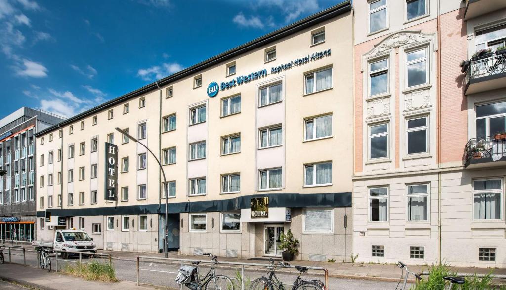 un grand bâtiment blanc avec des vélos garés devant. dans l'établissement Best Western Raphael Hotel Altona, à Hambourg