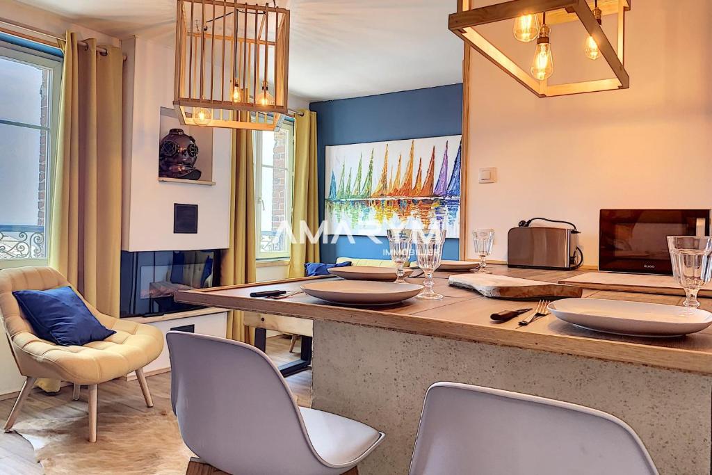 a kitchen with a bar with chairs and a table at AS 50 - Les bateaux au bord de l'eau in Ault