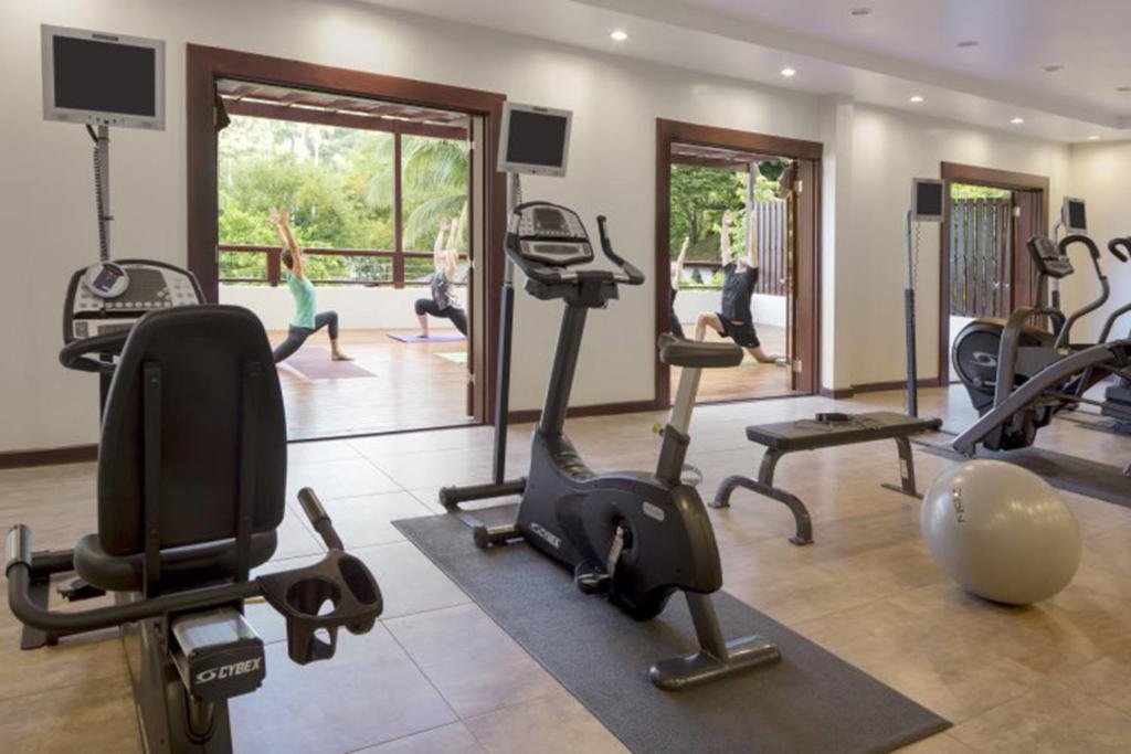 Un gimnasio con cintas de correr y bicicletas estáticas en una habitación. en Superb Split Level Waterside Apt, Marigot Bay, St Lucia WI, en Castries