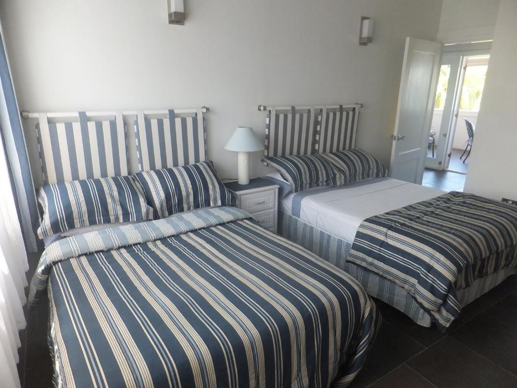 2 camas en una habitación de hotel con sábanas a rayas en Superb Split Level Waterside Apt, Marigot Bay, St Lucia WI, en Castries