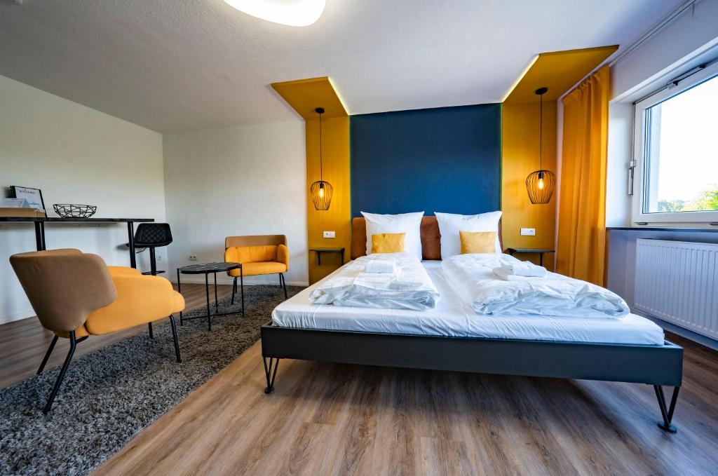 a bedroom with a bed with a blue headboard and chairs at Blissberg Winterberg in Winterberg