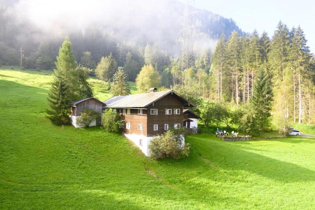 a house in the middle of a green field at Charming Alp Cottage in the Mountains of Salzburg in Bicheln