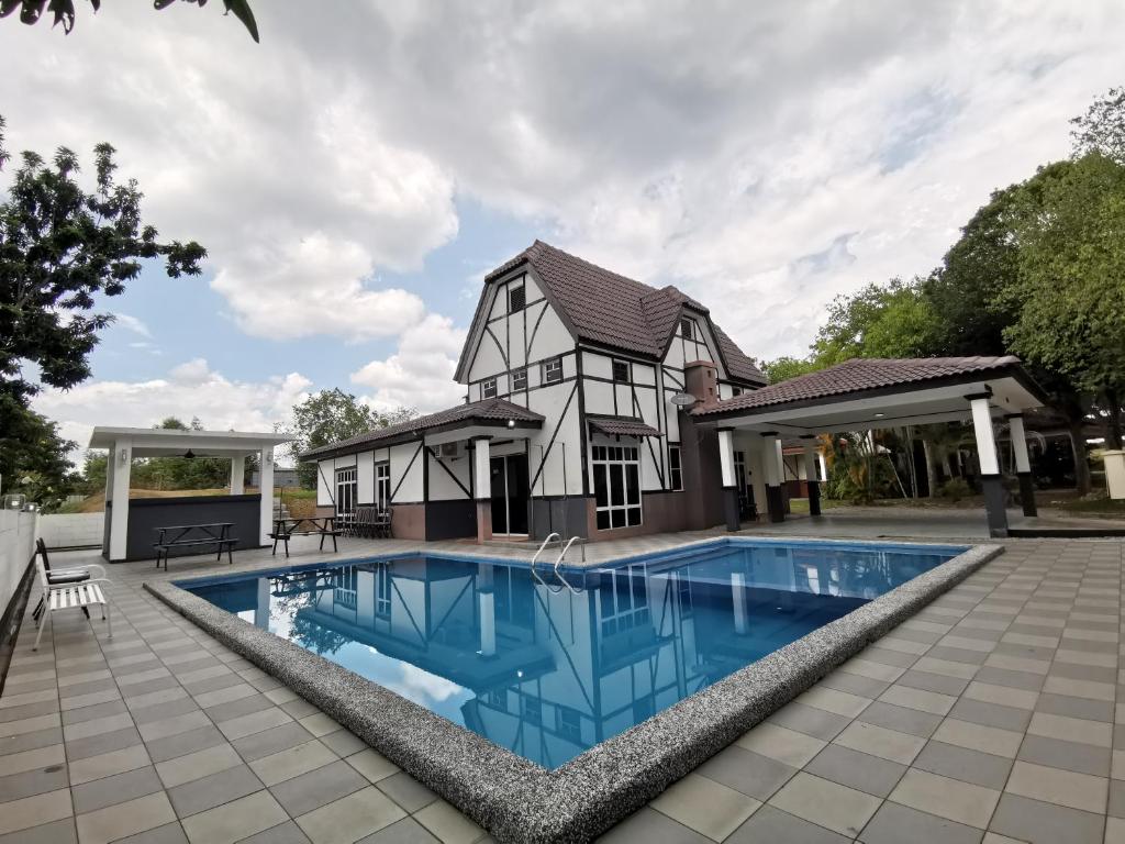 a house with a swimming pool in front of a house at BESLA HOMESTAY LOT986 at A'Famosa Resorts Melaka Villa, 5rooms, private pool, BBQ, KARAOKE with surcharge in Melaka