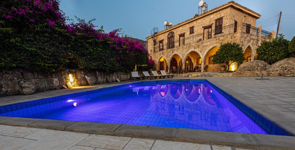 una piscina con iluminación púrpura frente a un edificio en Peace House Kyrenia en Kyrenia