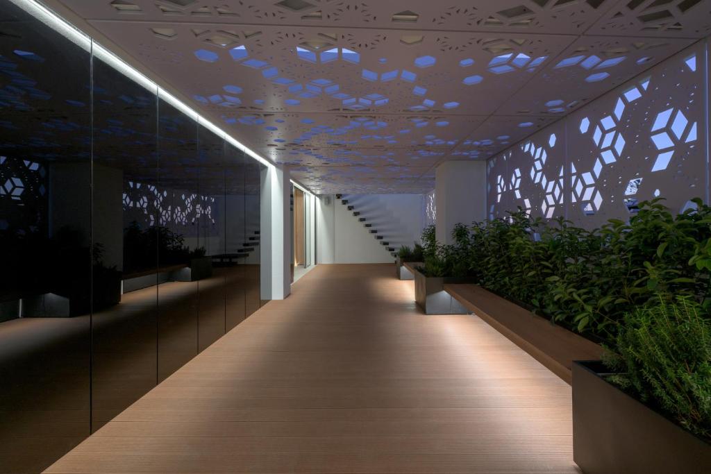 un pasillo con plantas y un techo con luces en Essence Suites Downtown Suites - Adults Only, en Rodas