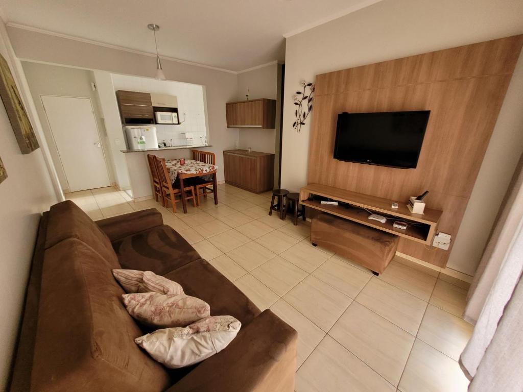 uma sala de estar com um sofá e uma televisão de ecrã plano em Olímpia Temporada Cond. Villagio em Olímpia