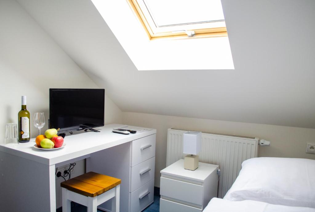 a bedroom with a desk with a computer and a bed at Penzión Pohoda in Nové Zámky