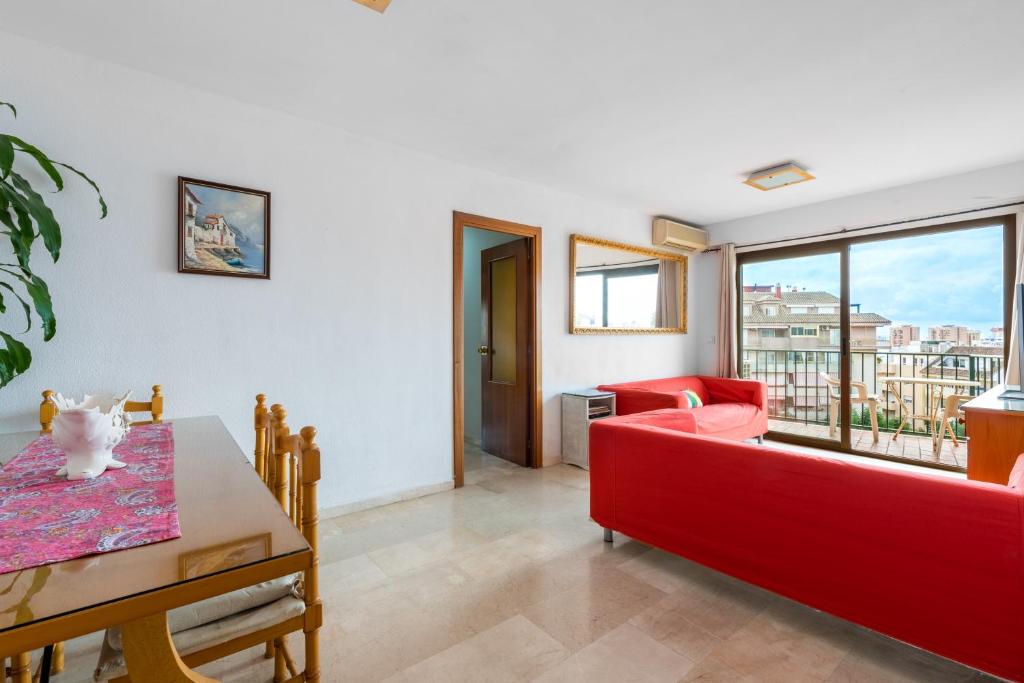 a living room with a red couch and a table at Fuengirola City Centre Apartment in Fuengirola